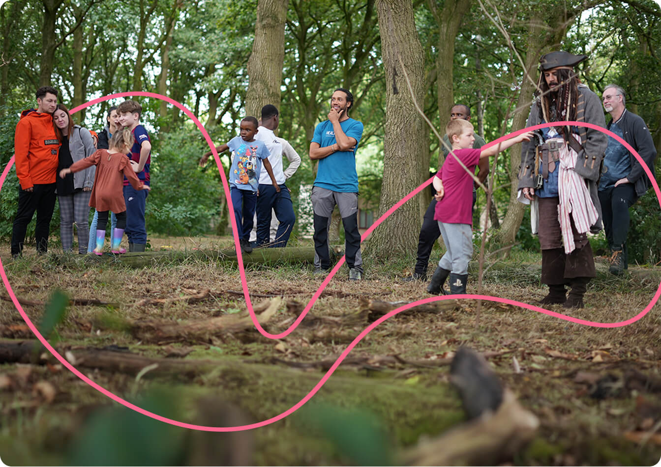 A group of young children in the woods surrounding Trafford Hall, accompanied by a man dressed as a pirate